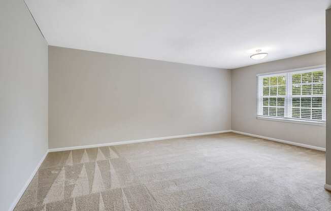 an empty room with a window and white walls