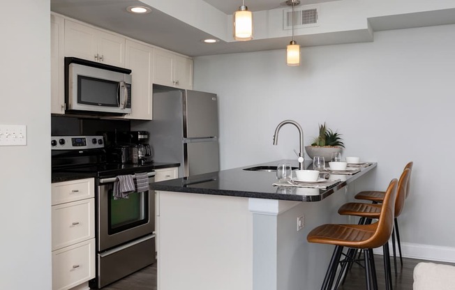 Modern kitchen featuring stainless steel appliances and a breakfast bar in these apartments for rent in Rittenhouse Square Philadelphia.