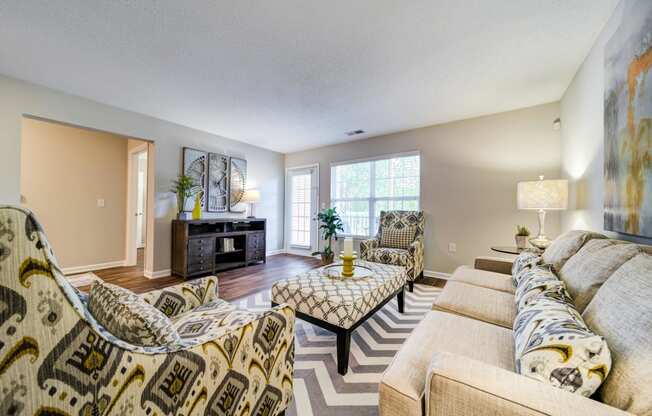 Large Living Room with Sofa, 2 chairs, Ottoman Coffee Table, Entertainment Stand, and Patio Door