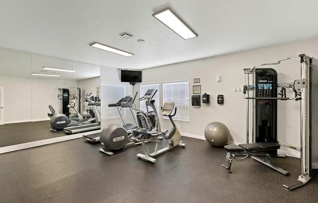 a gym with cardio equipment and weights at Serra Vista Apartment Homes, Lynnwood