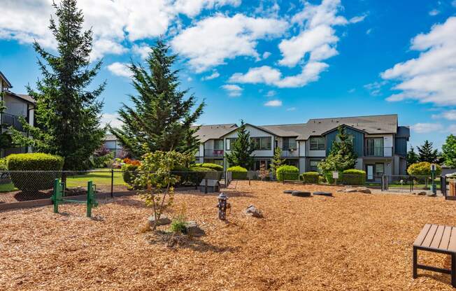 a courtyard with benches and trees in front of an apartment building