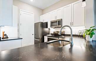 a modern kitchen with stainless steel appliances and black counter tops