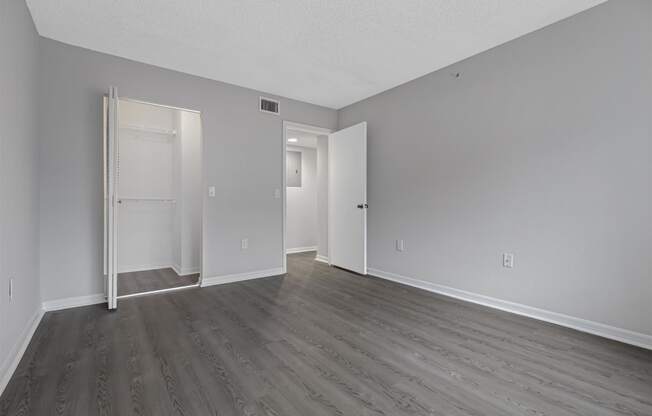 an empty living room with wood floors and white walls