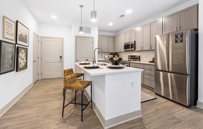 a kitchen with a large island and stainless steel appliances