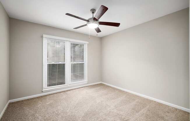 bedroom with large picture window and ceiling fan