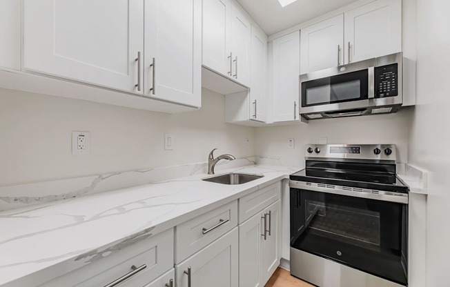 A kitchen with white cabinets and a black oven.