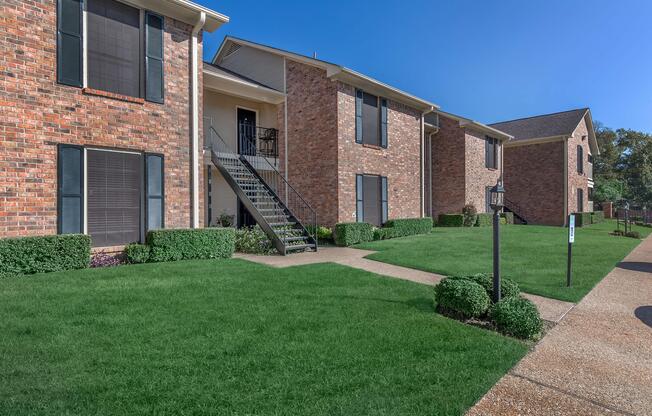 a large lawn in front of a brick building