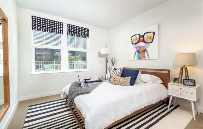 a bedroom with a bed and two windows