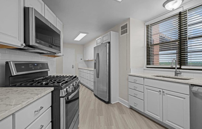 a kitchen with stainless steel appliances and white cabinets