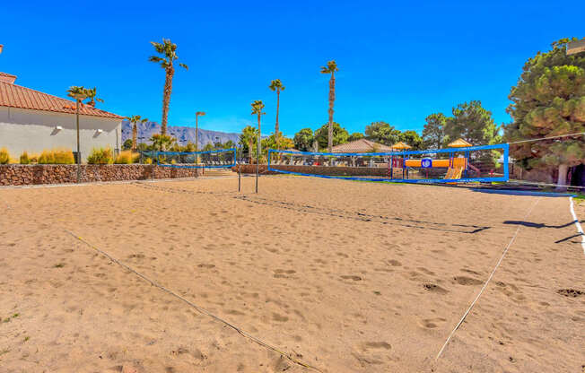 a sand volleyball court on a beach with palm trees