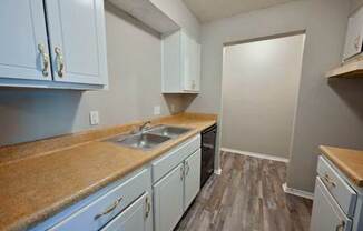A kitchen with light blue cabinets and a brown counter top.