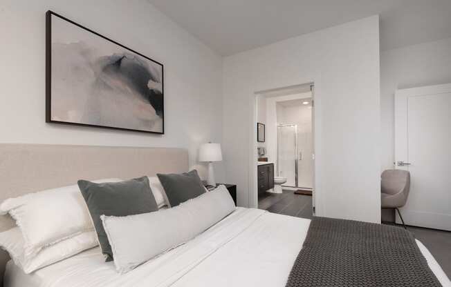 a bedroom with a large bed and a painting on the wall