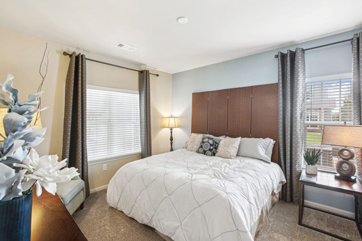 a bedroom with a large bed and two windows