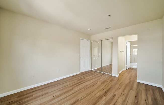 a bedroom with wood floors and white walls