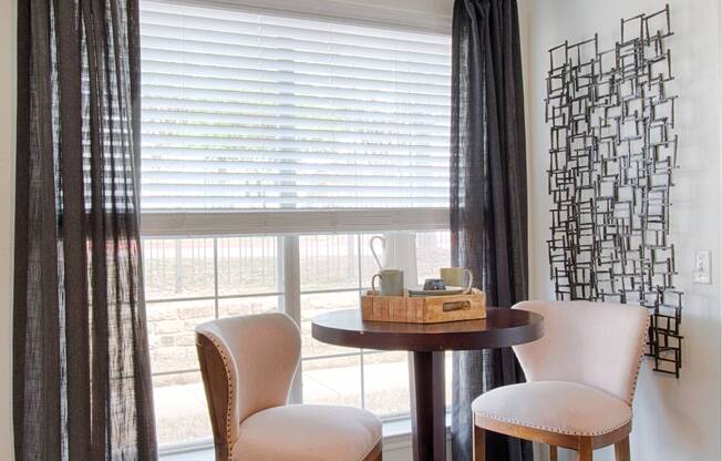 A table with two chairs and a basket on it.