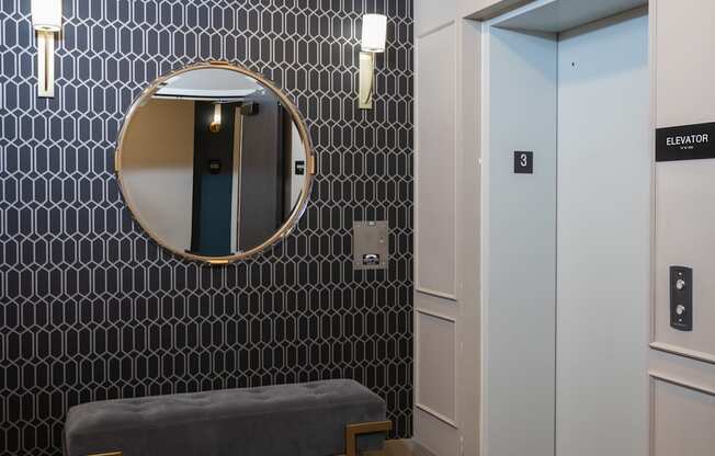 a seating area with a mirror and a bench in front of a door