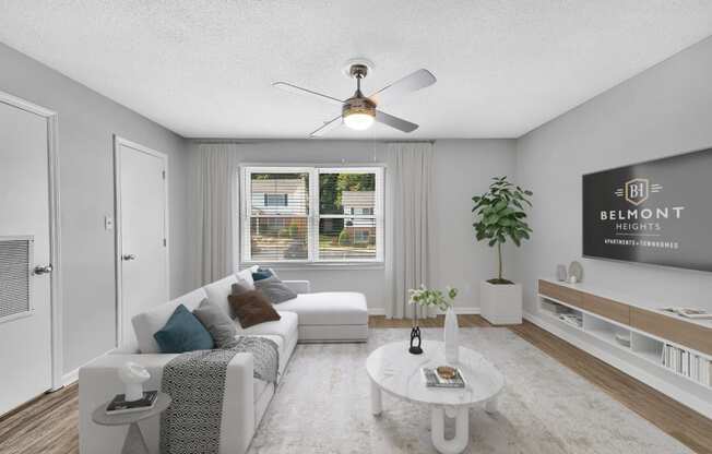 a living room with a white couch and a ceiling fan