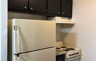 A white refrigerator and stove in a small kitchen.