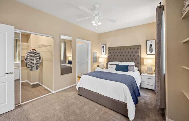 A bedroom with a large bed and a ceiling fan.