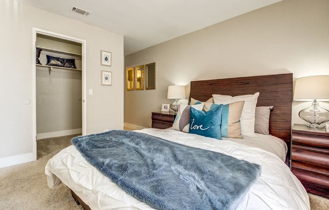 A bedroom with a bed covered in a blue blanket.