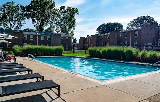 a swimming pool in front of a brick apartment building