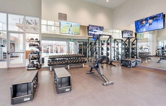 A gym with a variety of equipment including treadmills, weights, and exercise machines.