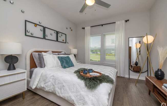 A bedroom with a bed, nightstand, and a mirror.