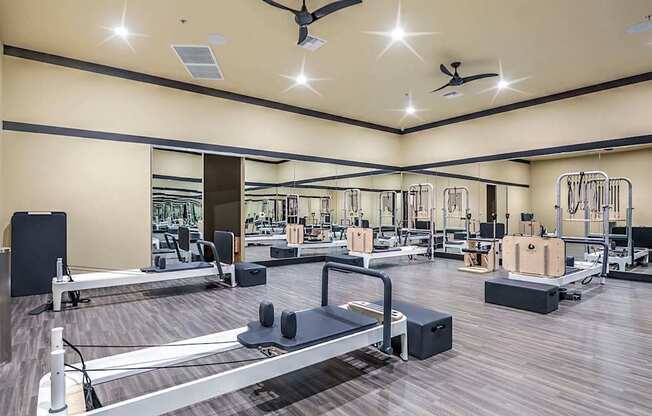 A gym with a variety of equipment including treadmills, weights, and exercise machines.