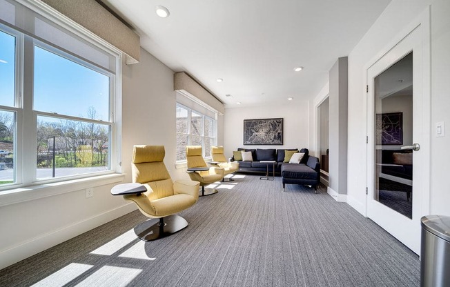 a large living room with chairs and a fireplace