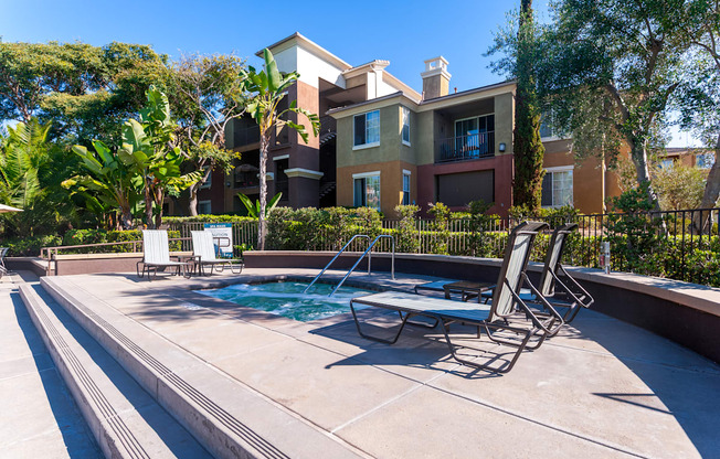 A pool with a table and chairs in front of a building.