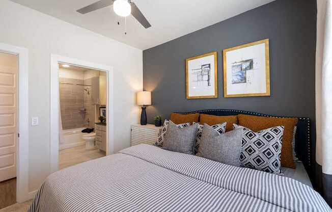 A bedroom with a large bed and two framed pictures on the wall.