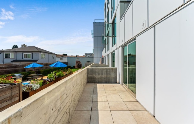 a balcony with a stone wall and a glass building