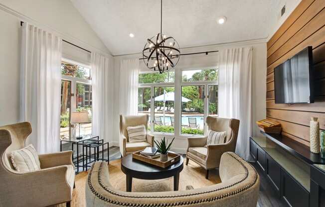 a living room with a table and chairs and a large window