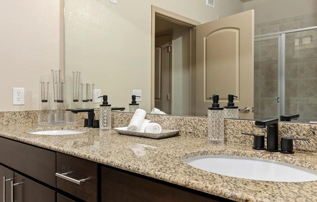 A bathroom with two sinks and a large mirror.