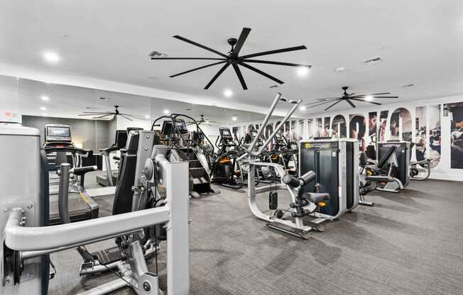 a large fitness room with cardio machines and other exercise equipment