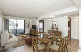 a living room and dining room with a wooden table and chairs