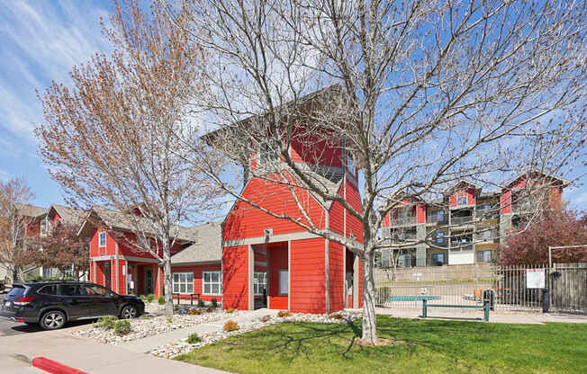 A red building with a black car parked in front.