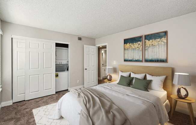 a bedroom with a large bed and two paintings on the wall at The Reserve At Barry Apartments, Kansas City, MO