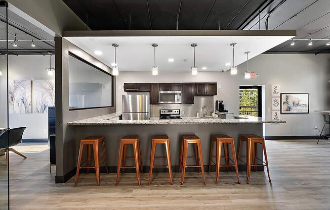 a kitchen with a counter and bar stools at Troy Place Apartments - Troy, MI, Troy