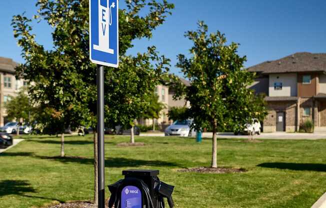 A blue and white sign with a black charging station underneath it.