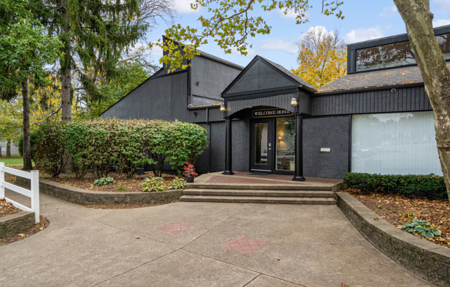 A black building with a glass door and a sign that says