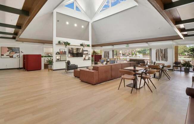 a large living room with a high ceiling and a dining room with tables and chairs at Summerwood Apartments, Santa Clara, CA 95050