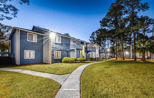 A row of houses with a sidewalk in front.