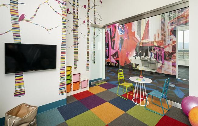 Playroom with bright colored carpet square carpeting at Parc West Apartments, Draper, Utah