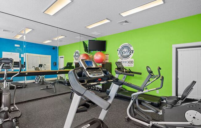 a gym with various exercise equipment and mirrors