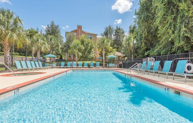 Tallahassee, FL apartment complex sparkling resort-style swimming pool and hot tub with lounge chairs at Evergreens at Mahan