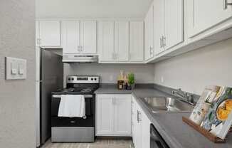 a white kitchen with stainless steel appliances and white cabinets