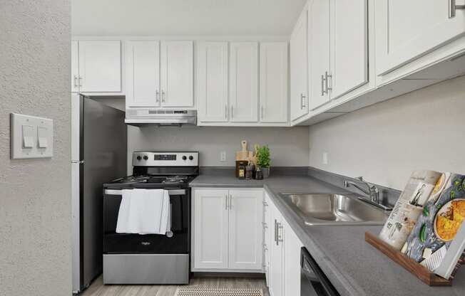 a white kitchen with stainless steel appliances and white cabinets