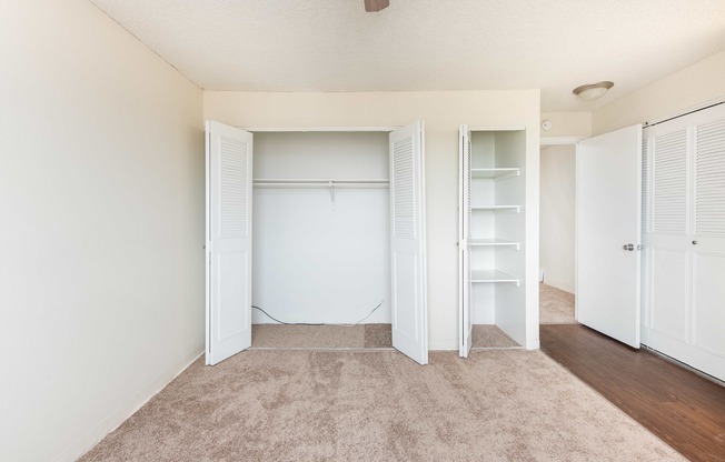 a bedroom with white closets and a carpeted floor