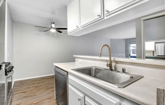 a kitchen with a sink and a ceiling fan